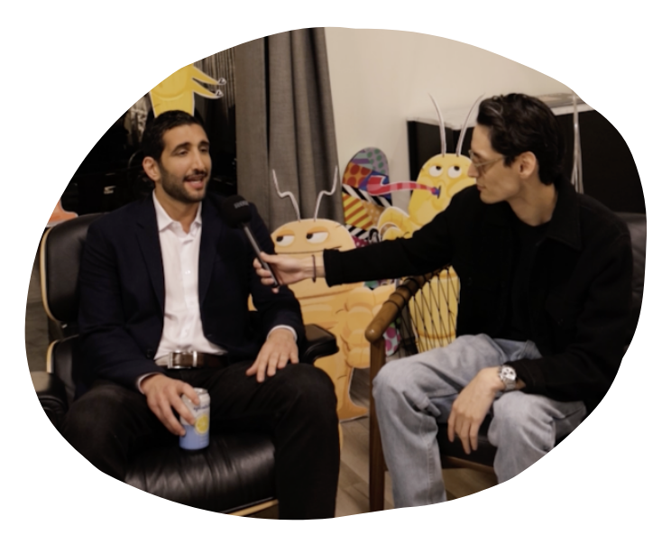 two people sitting in chairs surrounded by cartoon mite cutouts having a conversation